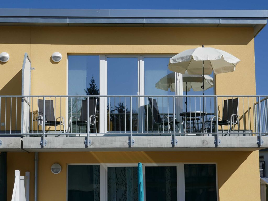 Südbalkon mit Sitzmöbeln und Sonnenschirm