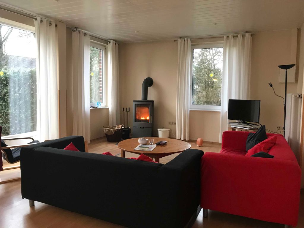 Wohnzimmer mit großem Esstisch und Kaminofen