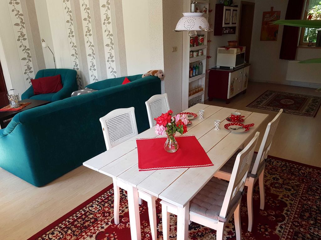 Wohnzimmer mit Couch, Esstisch und offener Küche