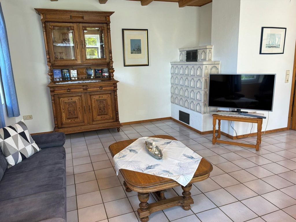 Wohnzimmer2. Gemütliches Wohnzimmer mit Kachelofen, rustikalem Buffetschrank, TV und bequemer Couch für entspannte Abende im Ferienhaus.