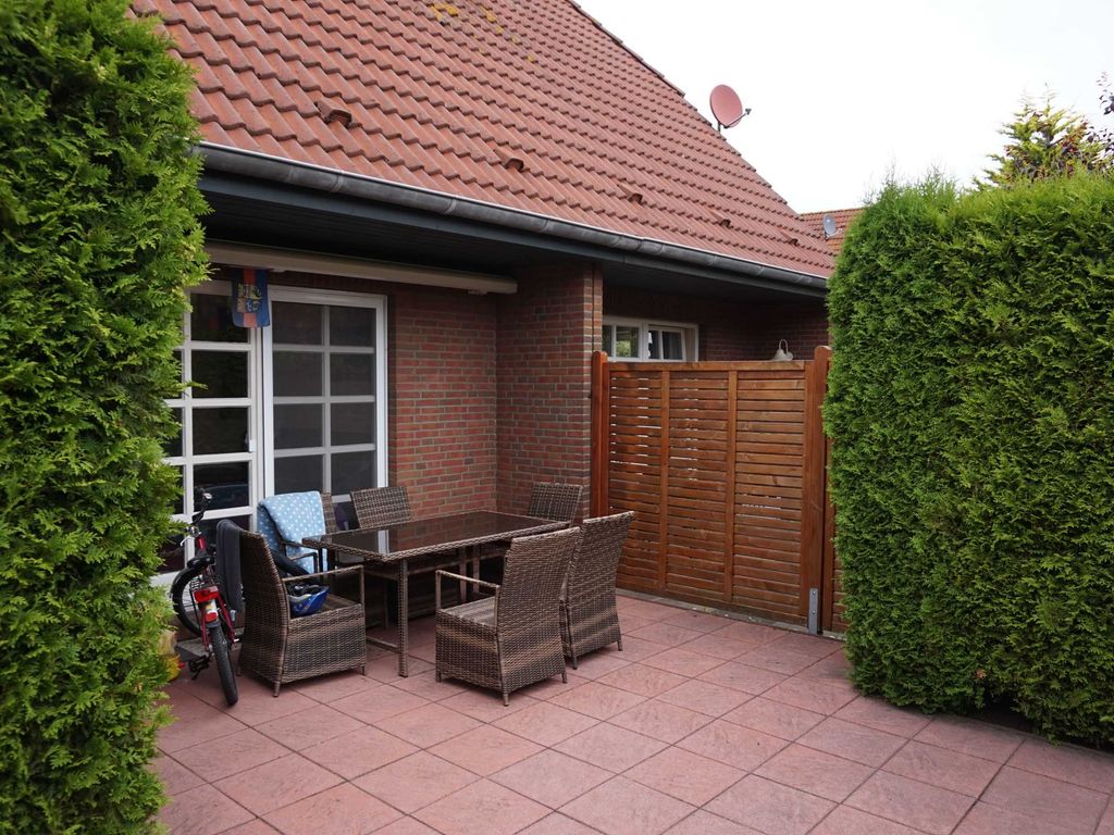 Terrasse mit elektrischer Markise und Möbeln.