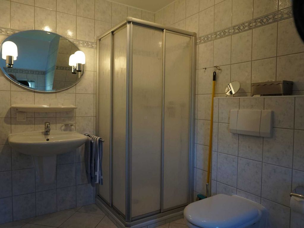 Badezimmer mit Dusche, Waschbecken und WC, Fenster
