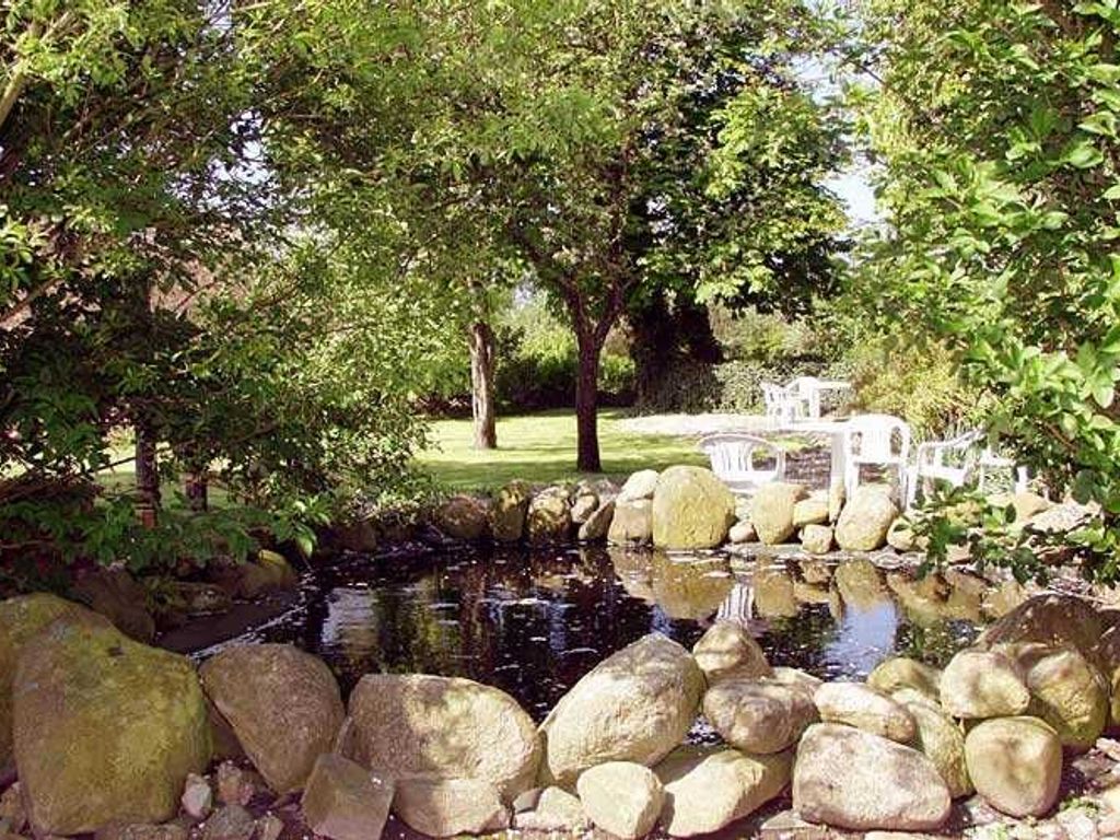Der weiträumige Garten lädt mit seinem alten Baumbestand und gepflegten Anlagen an zahlreichen, idyllischen Plätzen zum Verweilen ein, umgeben von einer üppigen heimischen Flora.