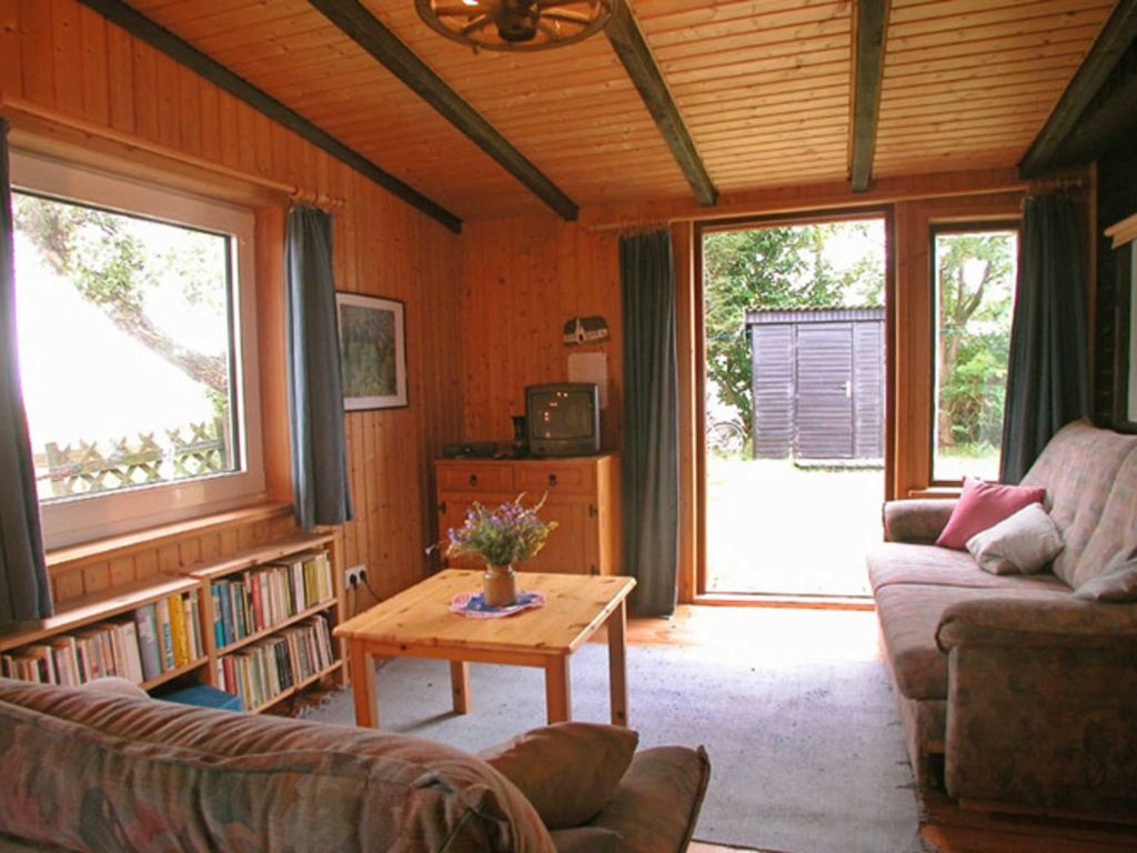 Wohn-Schlafzimmer mit Sat-TV und kleiner Bibliothek. Blick in den Garten und Richtung Meer