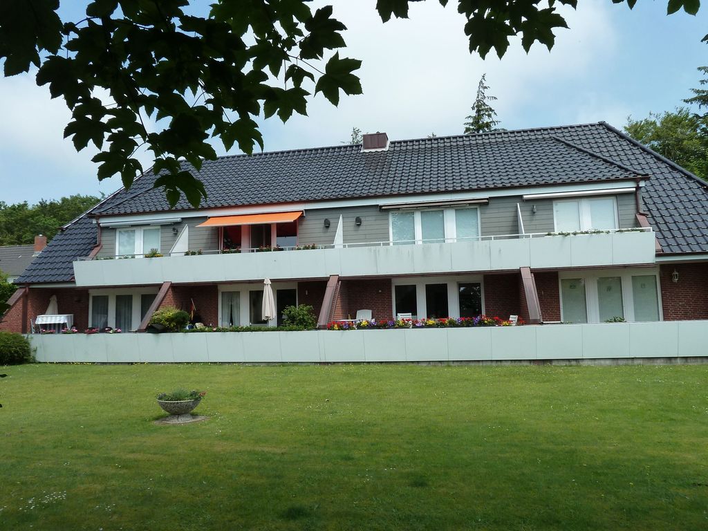 Hausansicht Vorderseite. Die angebotene Wohnung ist im 1.Stock die 2te von links mit der orangenen Markise.