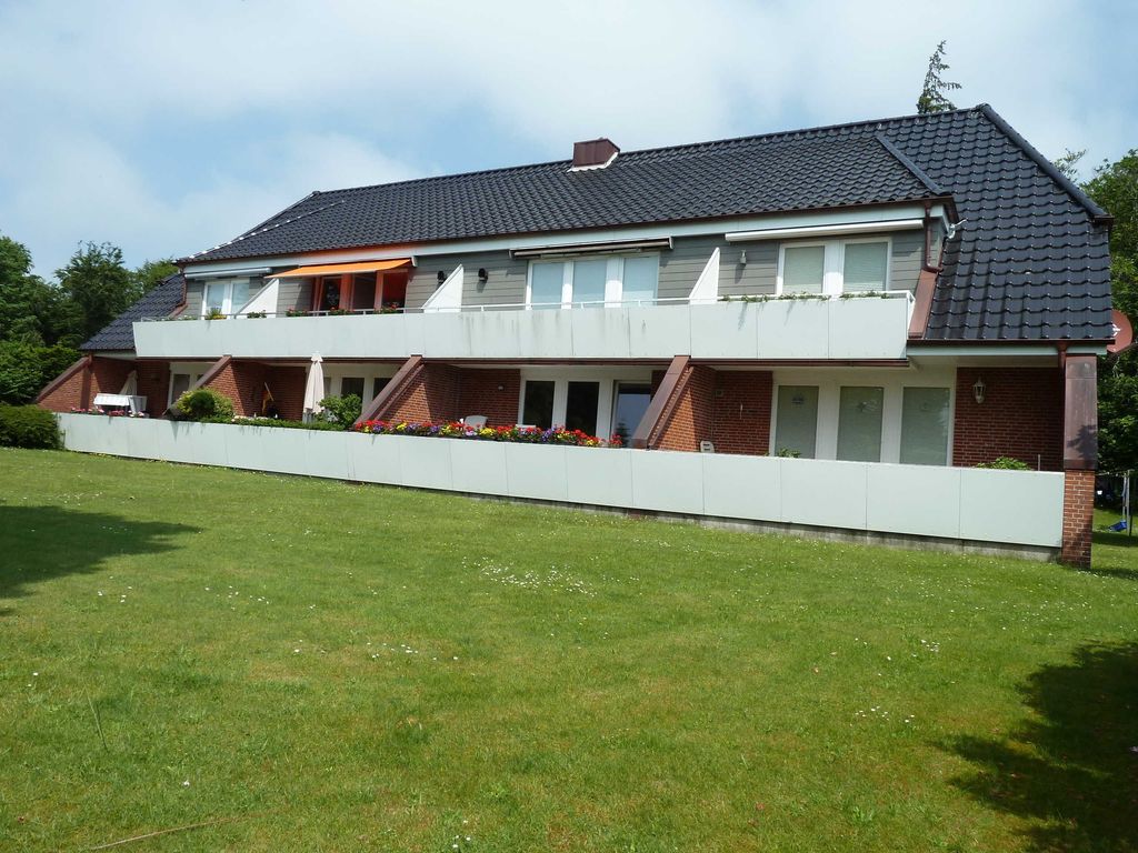 Hausansicht Vorderseite. Die angebotene Wohnung ist im 1.Stock die 2te von links mit der orangenen Markise.