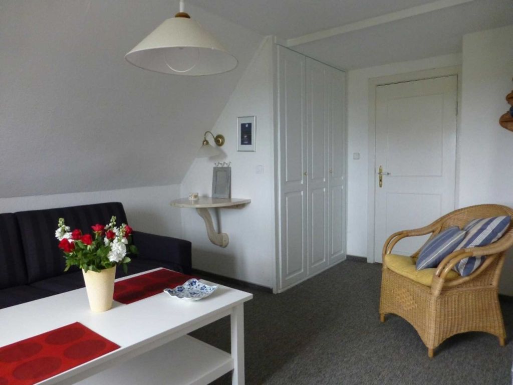 Wohnraum mit Einbauschrank, Fernseher und Schlafcouch