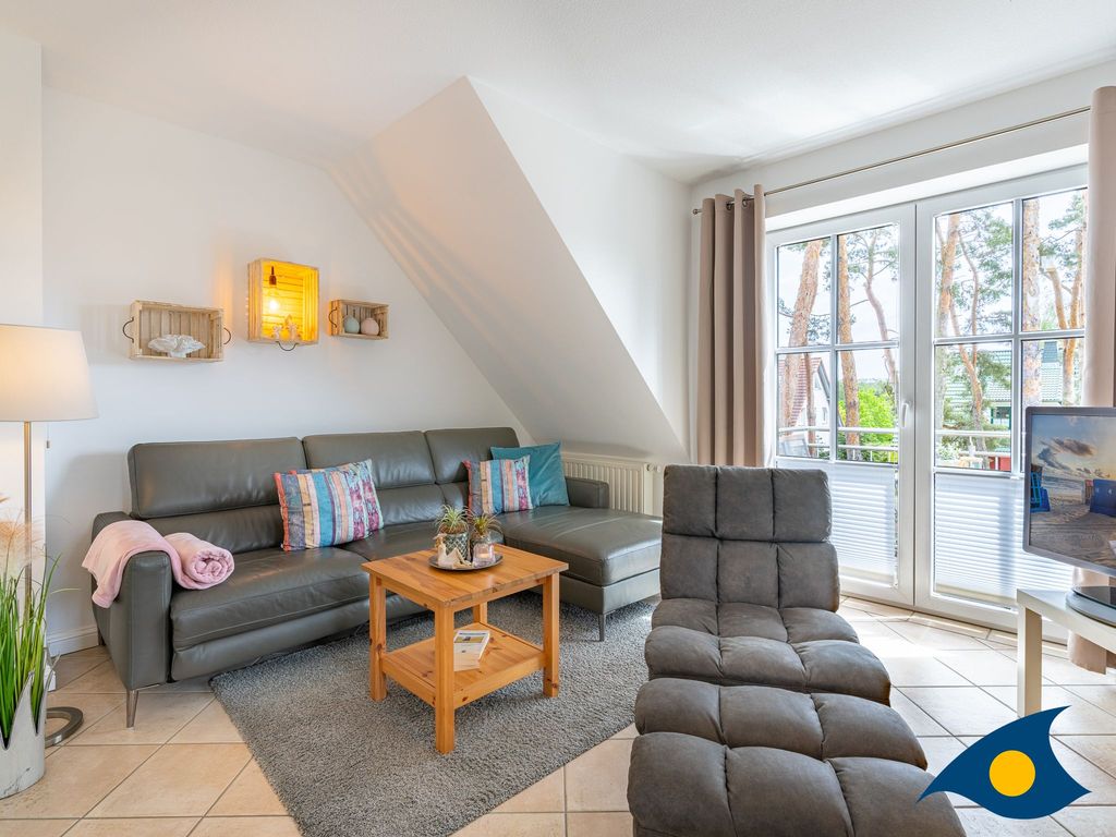 Wohnbereich mit offener Küche und Zugang zum Balkon