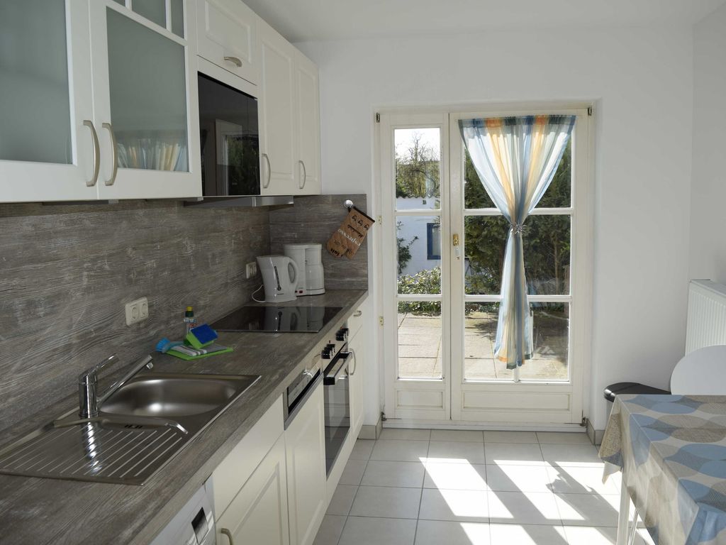 Küche. Helle, moderne Einbauküche im Ferienhaus mit direktem Terrassenzugang und Blick ins Grüne  ideal für Ihren entspannten Urlaub.