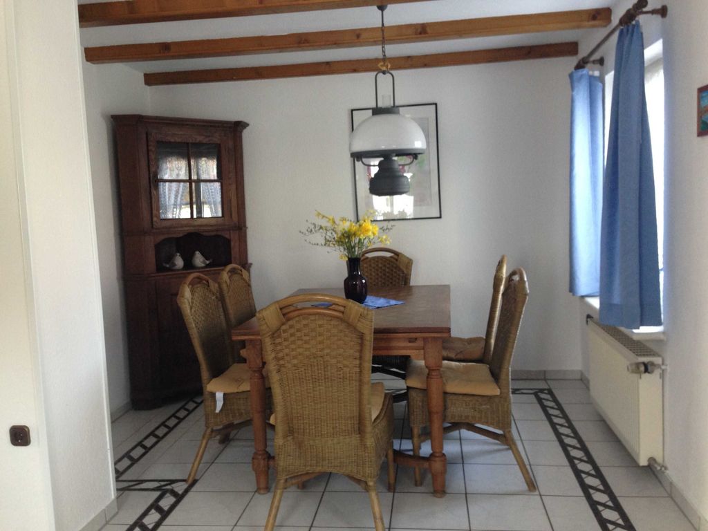 Wohnzimmer Essbereich. Gemütlicher Essbereich mit Holztisch und Stühlen im hellen Ferienhaus, ideal für entspannte Mahlzeiten im Urlaub.