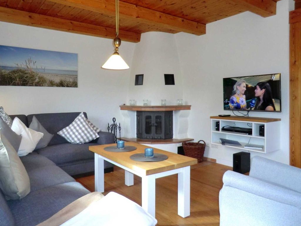 Weiterer Wohnbereich mit schwenkbarem Flat-TV und Kaminofen