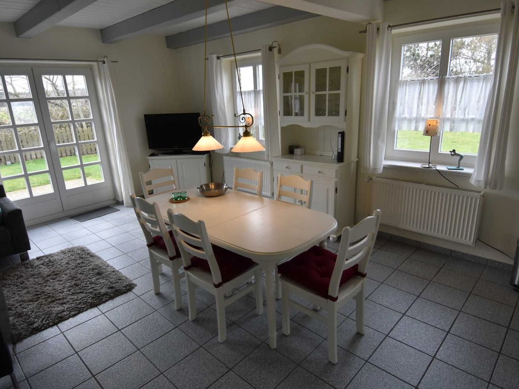 Helles Wohn- und Esszimmer mit Flat-TV und Terrassenausgang