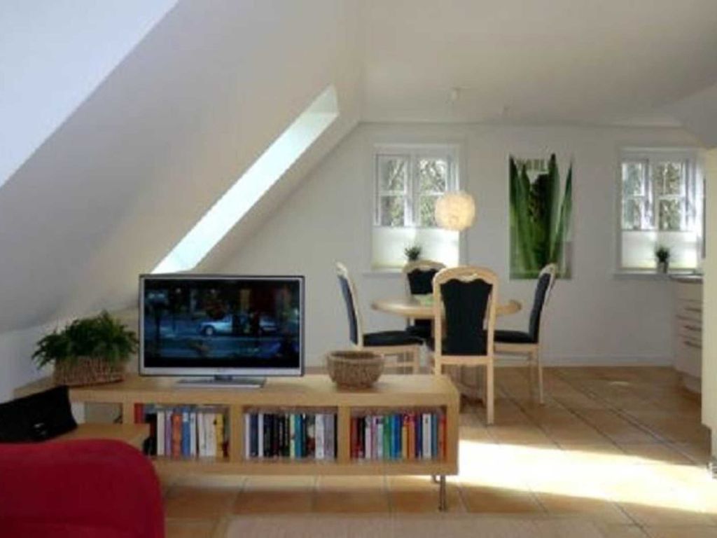 Blick über den Flat-TV zum Essbereich mit angrenzender, offener Küche
