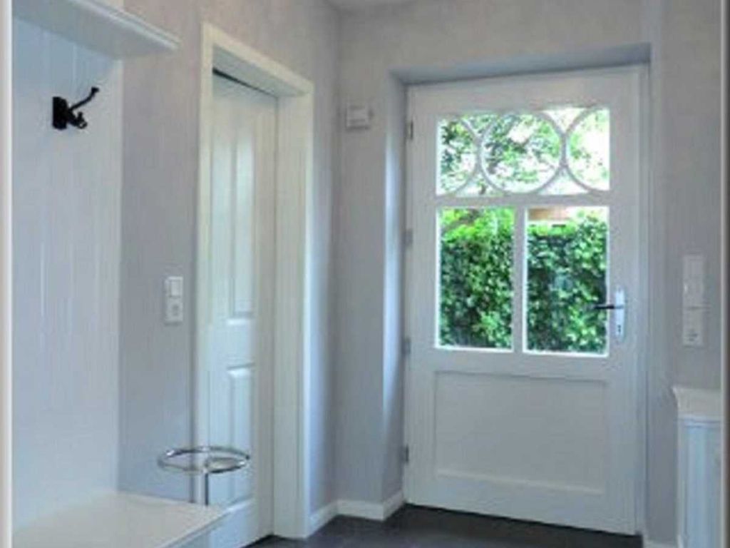 Heller Eingangsbereich mit Garderobe und großem Spiegel