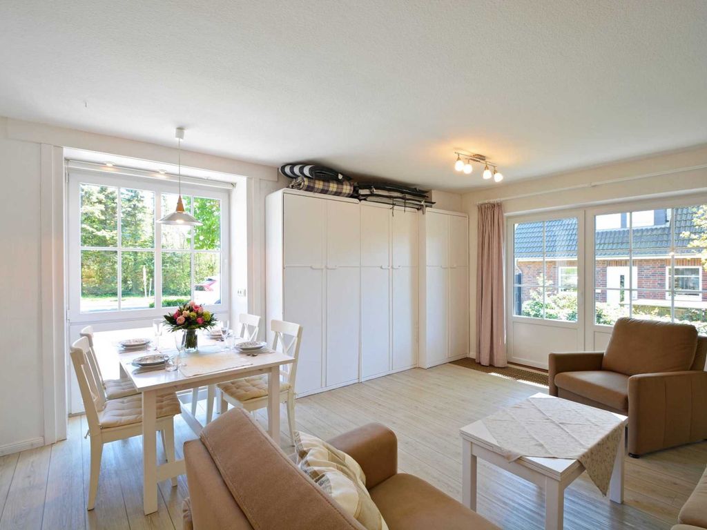 Das Wohnzimmer befindet sich im Erdgeschoss mit Essecke, Küche, Farb-TV, Radio und Schrankbetten.
