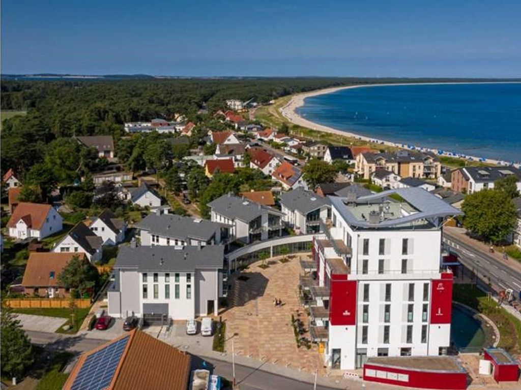 Luftbild der Küste bei Glowe mit dem Haus Bodden-Markt, dem Strand und der Schaabe