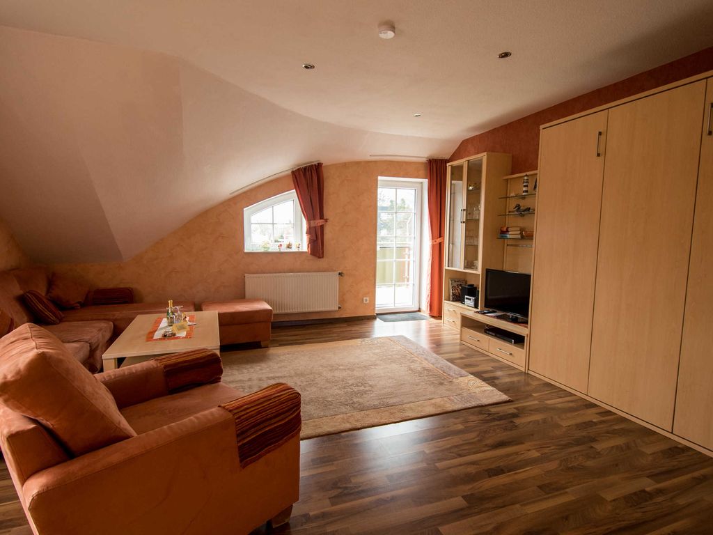 Das Wohnzimmer mit Sicht auf die Schrankwand und zum Balkon.