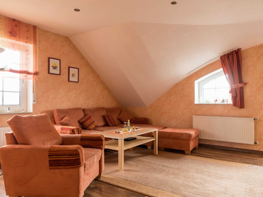 Das Wohnzimmer mit Sitzecke von der Eingangstür her betrachtet.