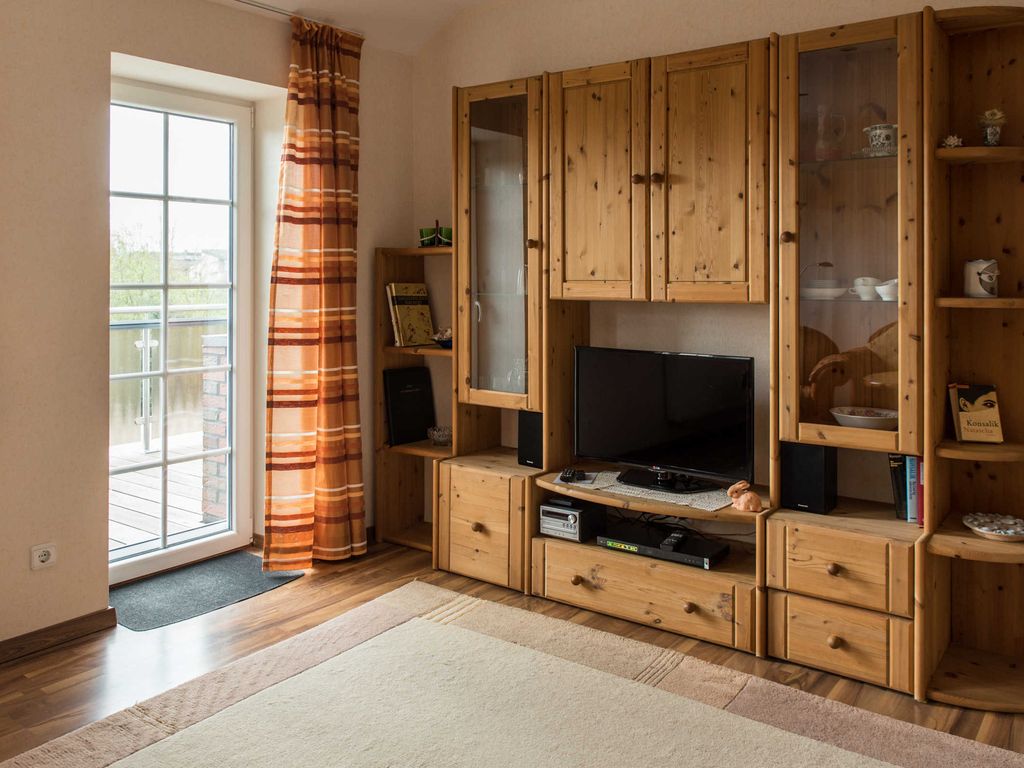 Das Wohnzimmer mit Sicht auf den Schrank und dem Zugang zum Balkon.