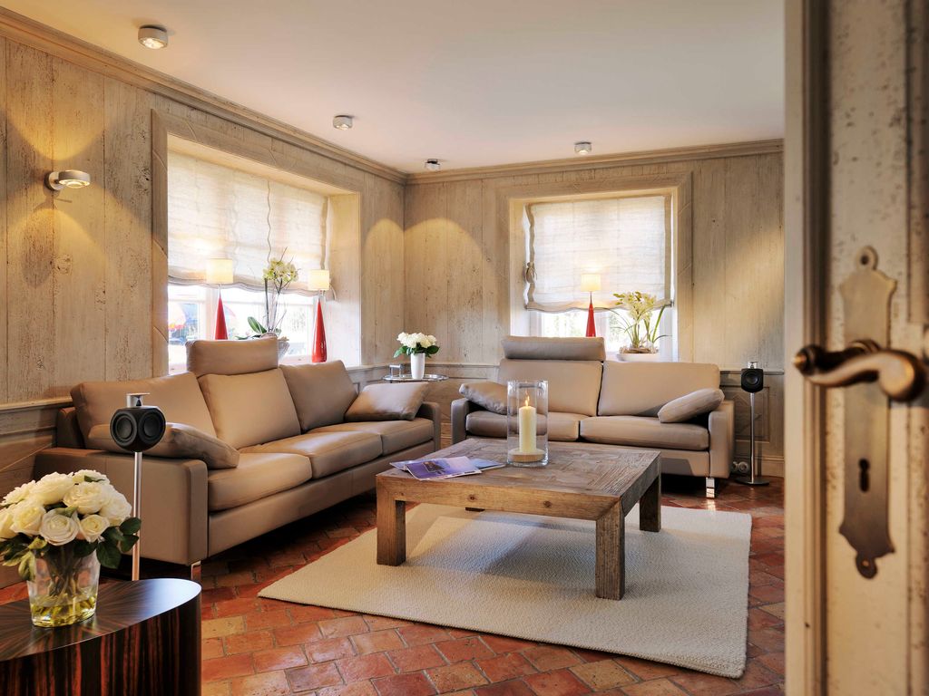 Wohnzimmer mit einem Sofa von COR und direktem Blick auf den Deich.  Poet-Plattenspieler und Sonus-Entertainment-System.