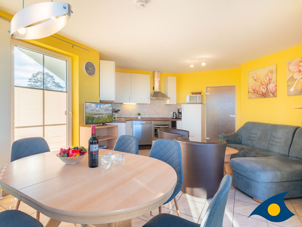 Wohnzimmer mit offener Küche und Zugang zur Terrasse