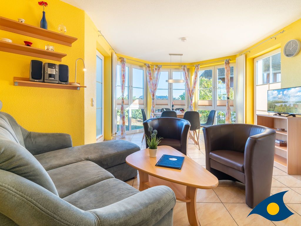 Wohnzimmer mit offener Küche und Zugang zur Terrasse