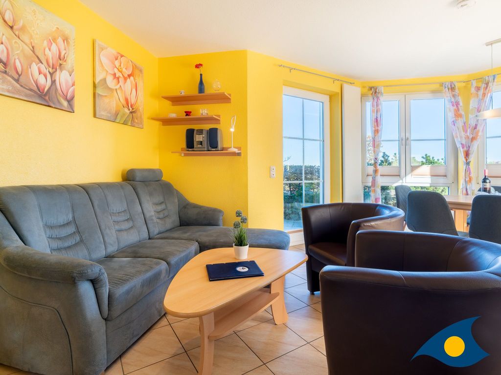 Wohnzimmer mit offener Küche und Zugang zur Terrasse