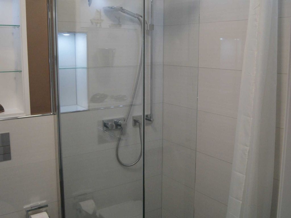 Bad. Das Duschbad mit bodengleicher Dusche in warmen Farbtönen.