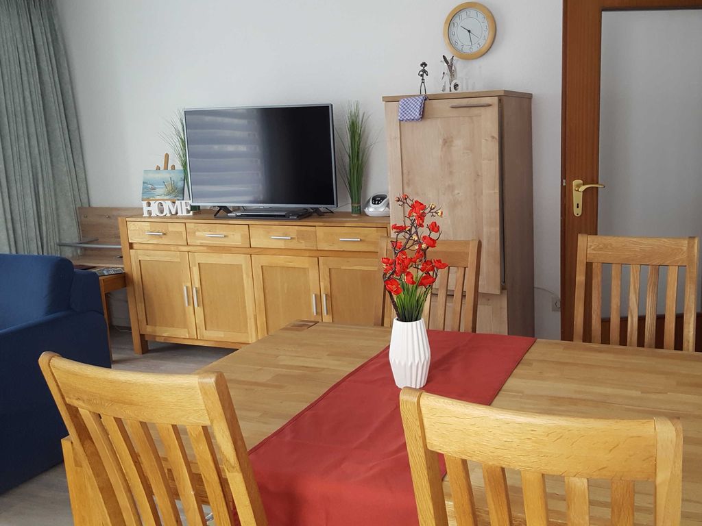 Wohnzimmer mit Essplatz und modernem Fernseher