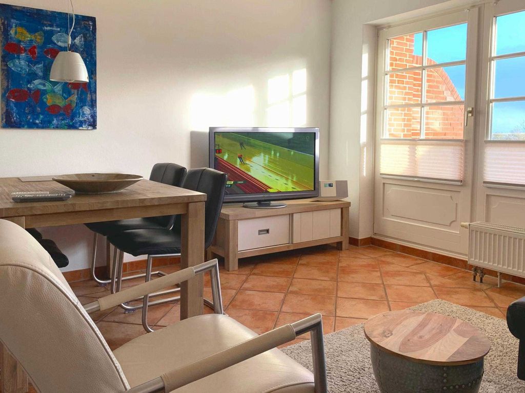 Weiterer heller Wohnbereich mit Terrassenausgang und großem Flat-TV