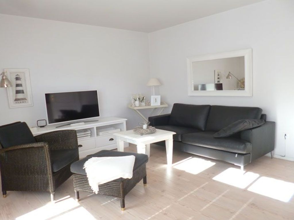 Das helle Wohnzimmer mit Komfortküchenzeile und Essplatz ist geschmackvoll und hochwertig eingerichtet.