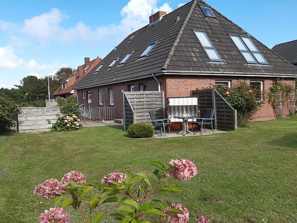 Helle OG-FeWo im Binnendörp 2a mit Terrassenplatz und Strandkorb im Garten.