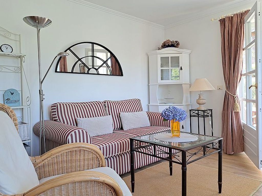 Das gemütliche Wohnzimmer mit Essplatz und direktem Zugang auf die Terrasse mit Strandkorb.