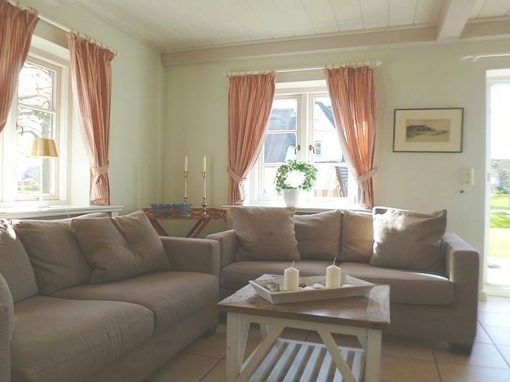 Das helle Wohnzimmer bietet einen direkten Zugang zum schönen Garten mit Gartenmöbeln und Strandkorb (April-Oktober).