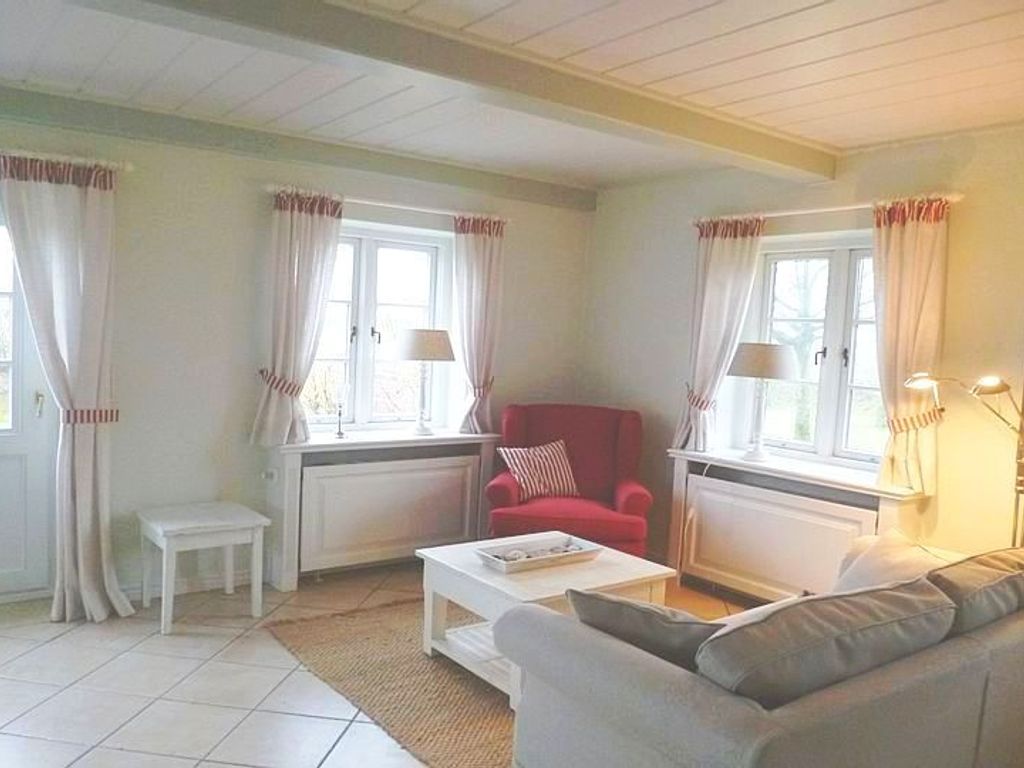 Vom Wohnzimmer aus gibt es einen direkten Zugang zum Südgarten mit Gartenmöbeln und Strandkorb (April - Oktober).