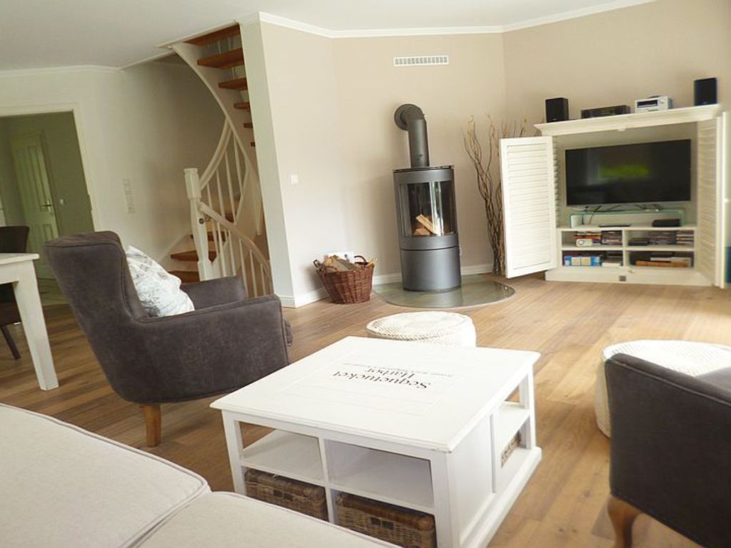 Im Erdgeschoß lädt ein geräumiges lichtdurchflutetes Wohnzimmer mit Kaminofen und Eßtafel Familien zum Wohlfühlen ein.