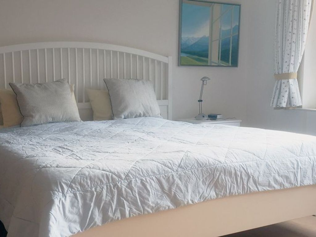 Das großzügige Schlafzimmer mit Doppelbett (180 x 200 cm) verfügt über ein Kinderbettchen für ein Kleinstkind.