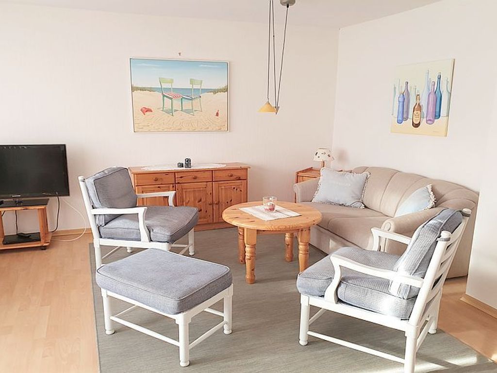 Das geräumige Wohnzimmer mit Essplatz und Schreibtisch bietet einen direkten Zugang zur Südterrasse mit Garten.