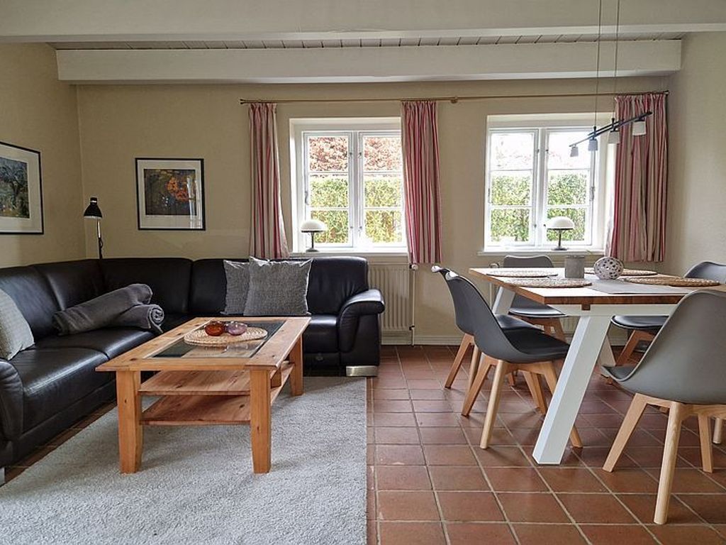 Im Erdgeschoss dieser Haushälfte befindet sich das gemütliche Wohnzimmer mit Kaminofen und einem Essplatz.