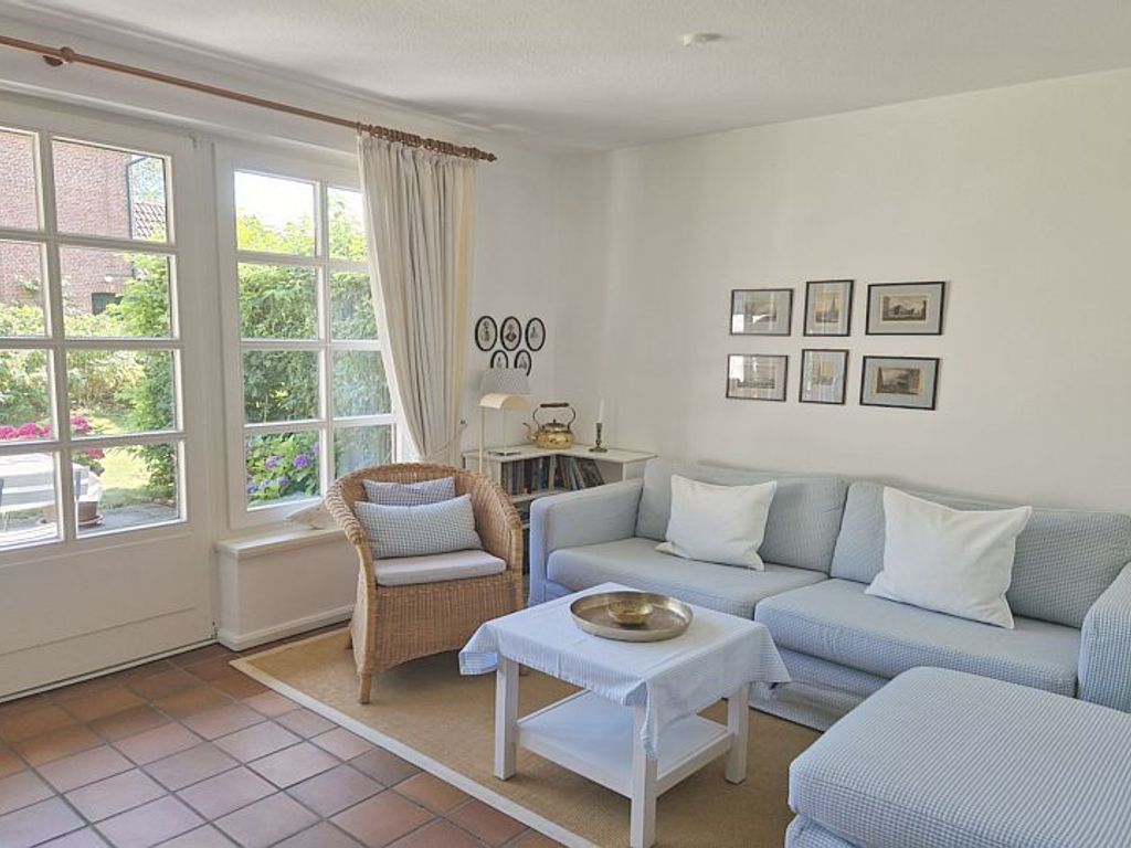 Im Erdgeschoß befindet sich das helle gemütliche Wohnzimmer mit Eßplatz und direktem Zugang zum Südgarten mit Gartenmöbeln und Strandkorb. (April-Okt.)