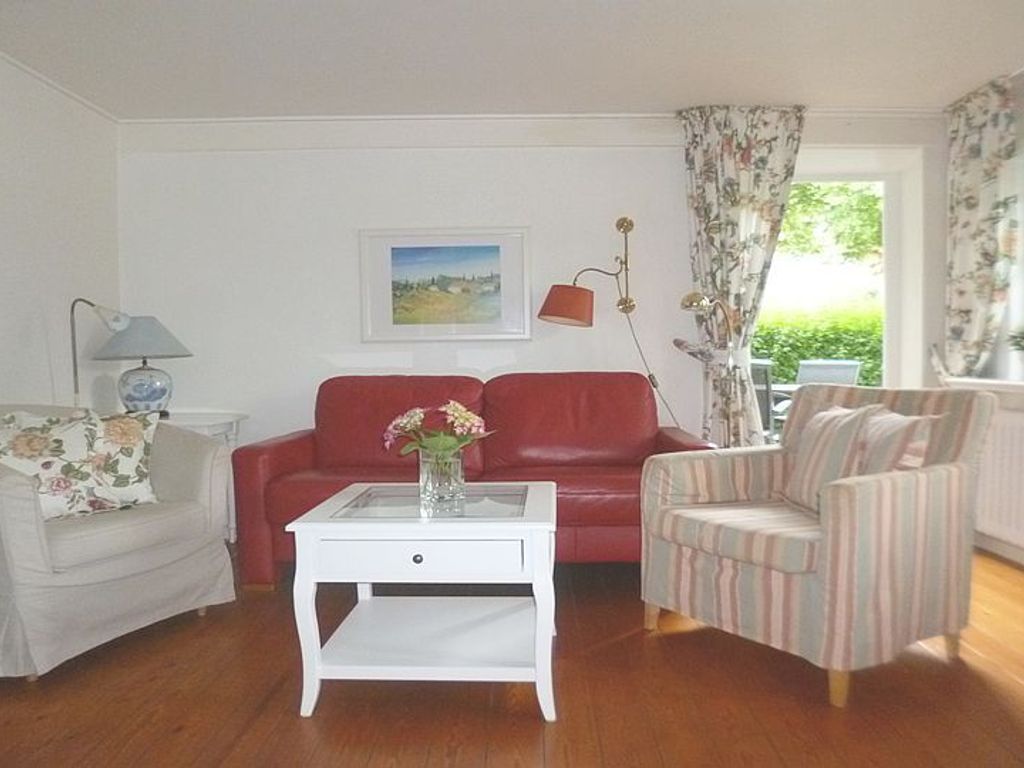 Das einladende Wohnzimmer mit seinen Holzdielen und dem Zugang zum Südgarten lädt durch schöne Accessoires sowie WLAN, Flachbild-TV und DVD-Player zum Wohlfühlen ein.