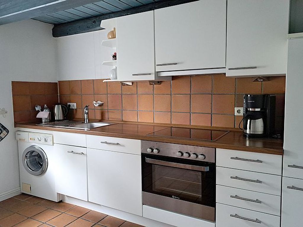 Im gefliesten Erdgeschoss befindet sich die separate Komfortküche mit Mikrowelle, Geschirrspüler und Waschmaschine.