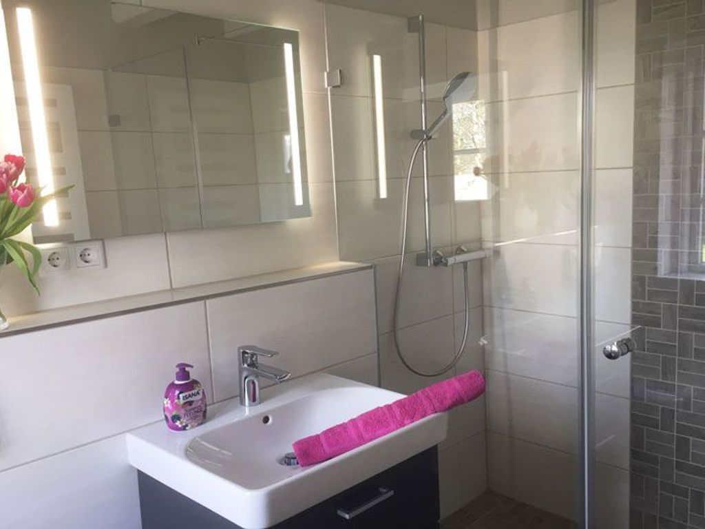 Das Badezimmer im Erdgeschoss ist mit einer walk in Dusche modern gestaltet.
