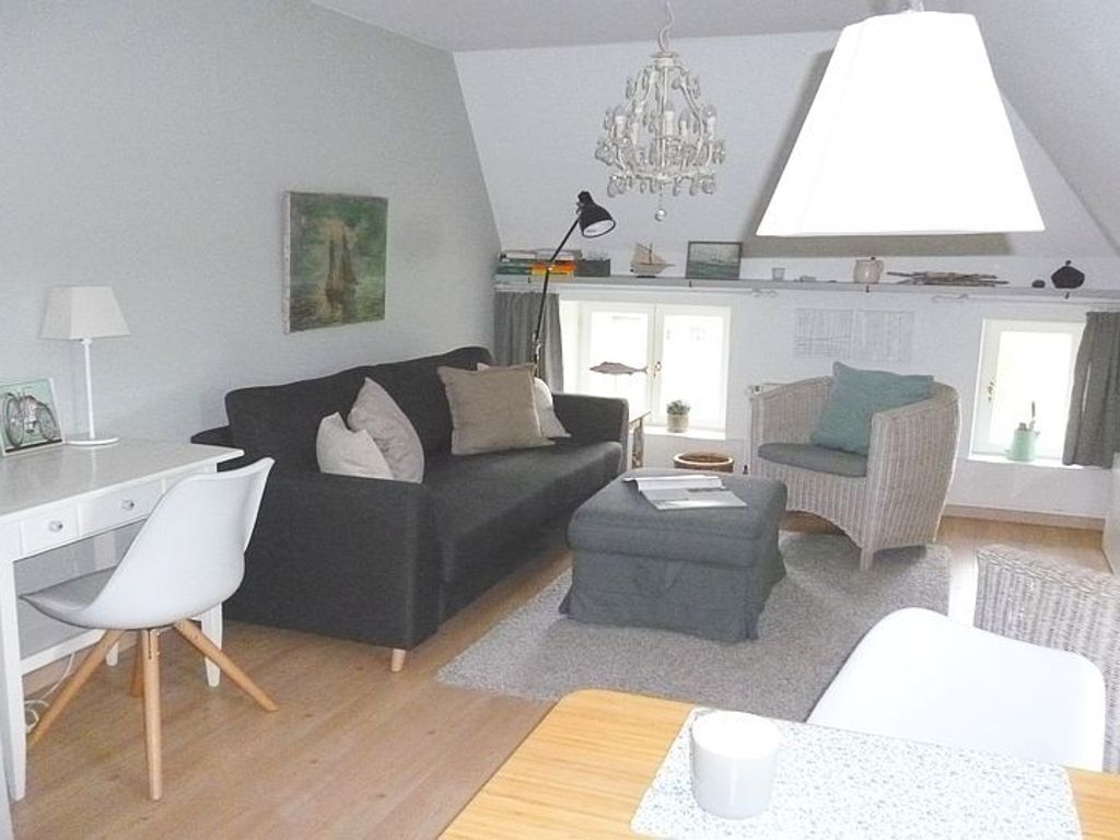 Das geschmackvoll eingerichtete Wohnzimmer verfügt über eine gemütliche Sofaecke und einen Essplatz.