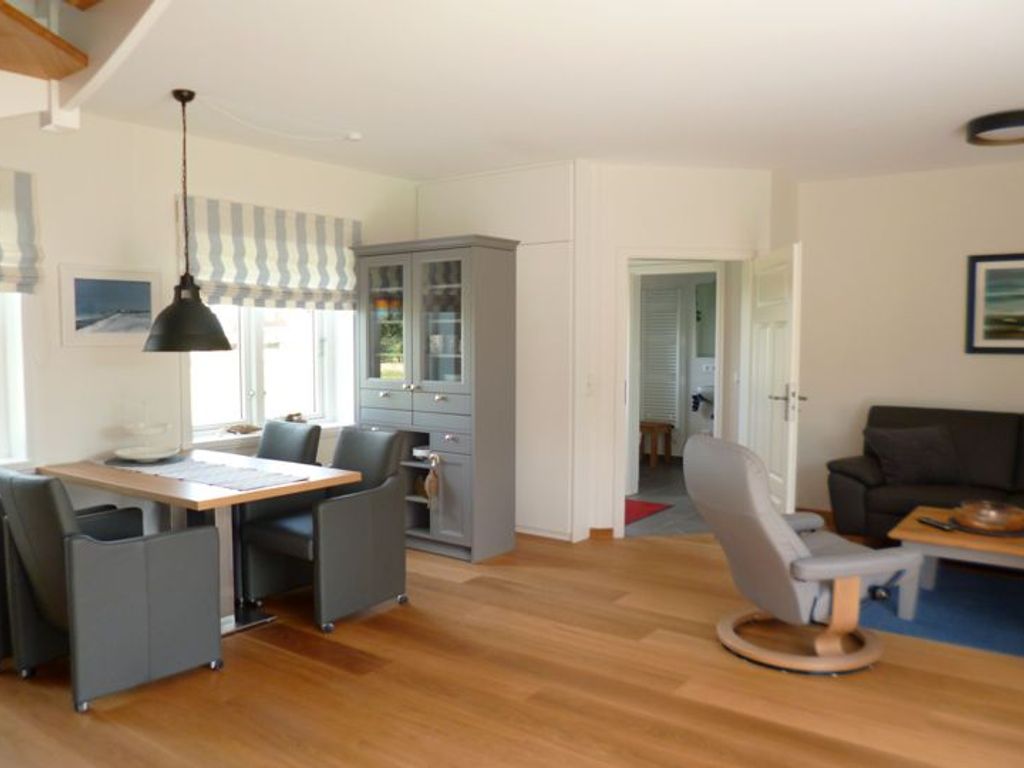 Das offene Wohnzimmer im Erdgeschoß bietet einen direkten Zugang zum möblierten Südgarten mit Gartenmöbeln und Strandkorb auf der Terrasse. (April-Okt.)