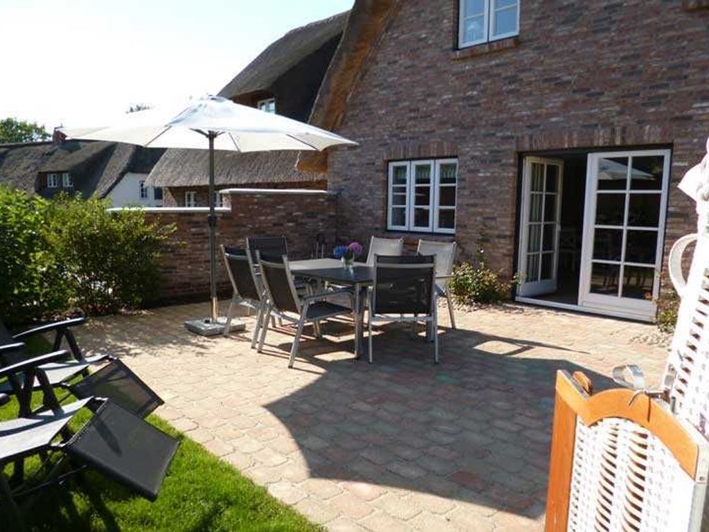 Vom Wohnzimmer gelangt man direkt auf die möblierte Südterrasse mit Strandkorb.