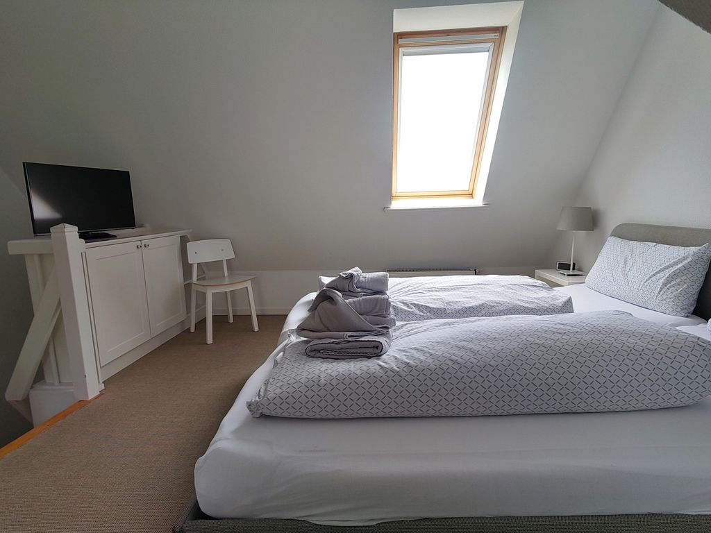Schlafzimmer im Dachgeschoß mit Doppeltbett und Einzelbett im Giebel