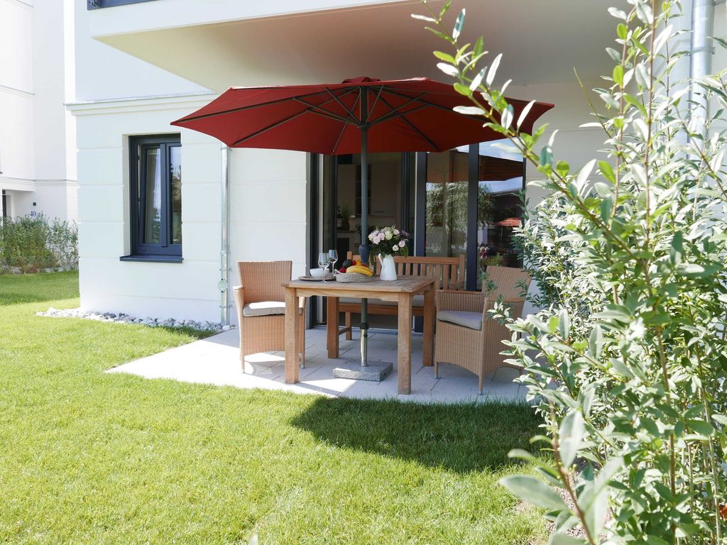 Baabe Villen Ensemble: Gartenterrasse einer Erdgeschosswohnung mit Sonnenschirm
