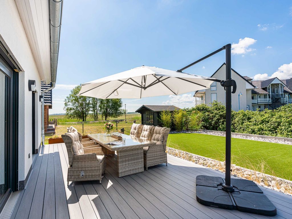 Das Ferienhaus Josefine im Ostseebad Karlshagen auf der Insel Usedom. Terrasse mit Gartenmöbeln und Sonnenschirm.