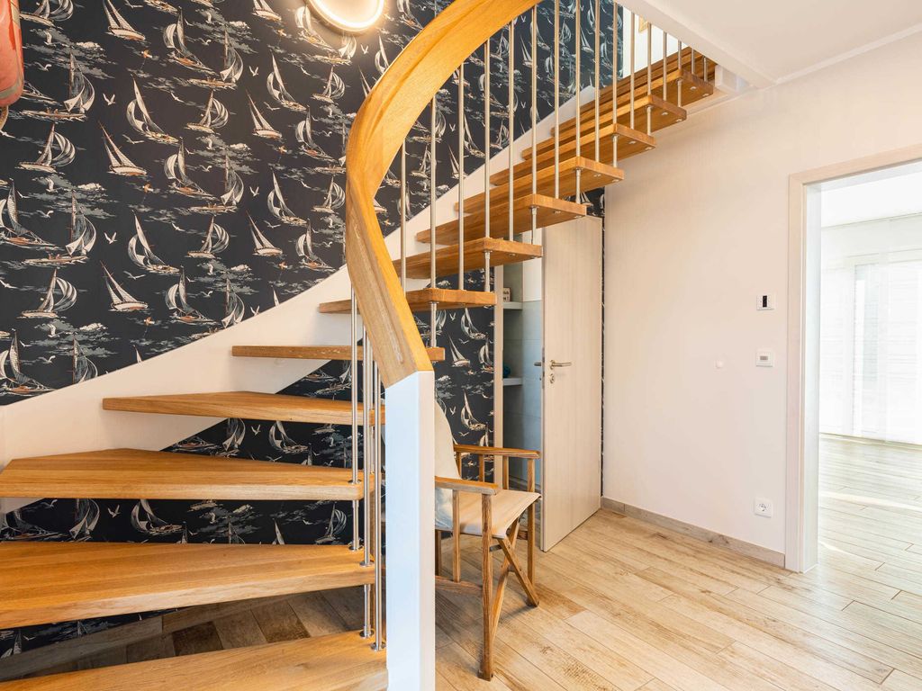 Das Ferienhaus Josefine im Ostseebad Karlshagen auf der Insel Usedom zeigt einen großen, hellen Eingangsbereich mit Treppe und Flur, der die Räume des Ferienhauses miteinander verbindet.